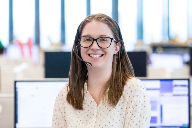 Call centre worker, smiling while wearing her headset