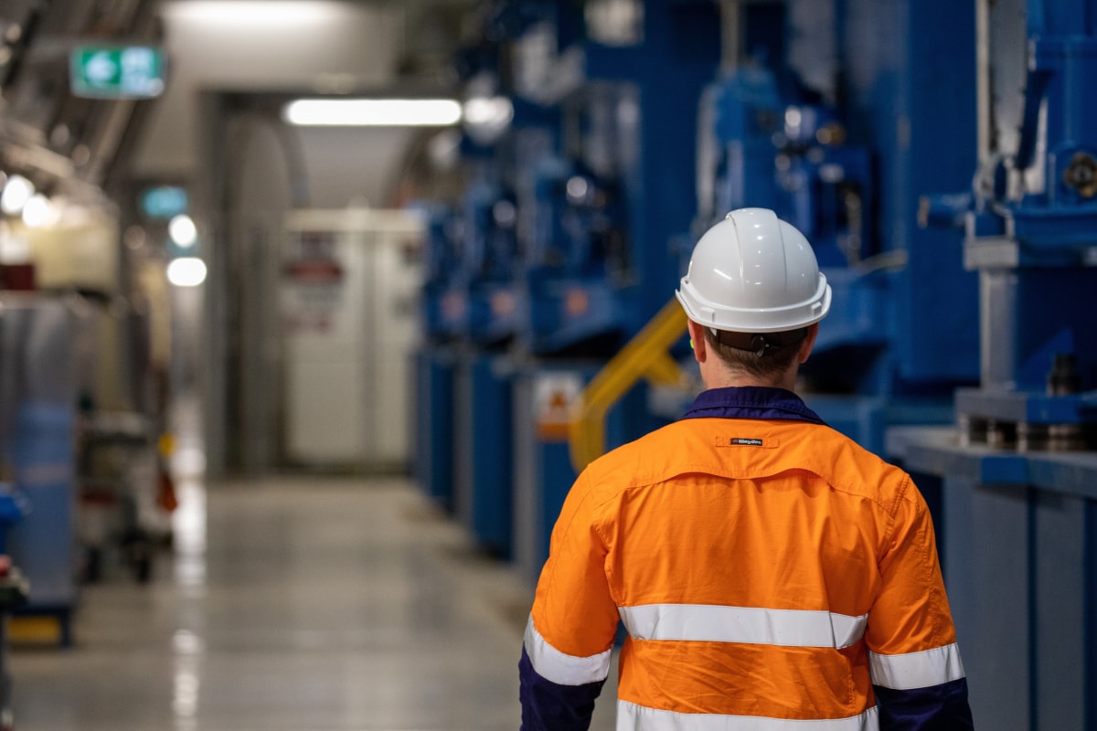 Worker walking past equipment at our Torrens and Eastwood site