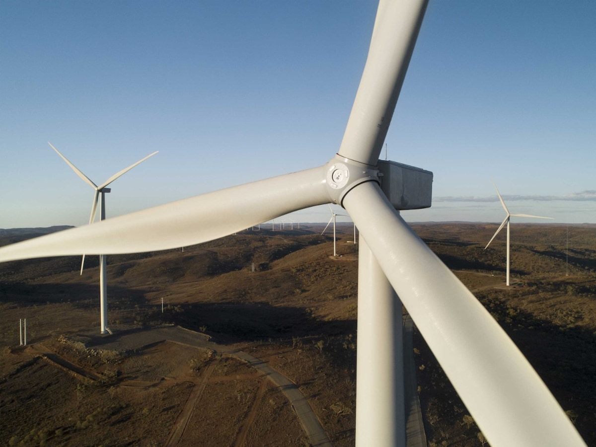 Close-up of white wind turbines in a field on a sunny day