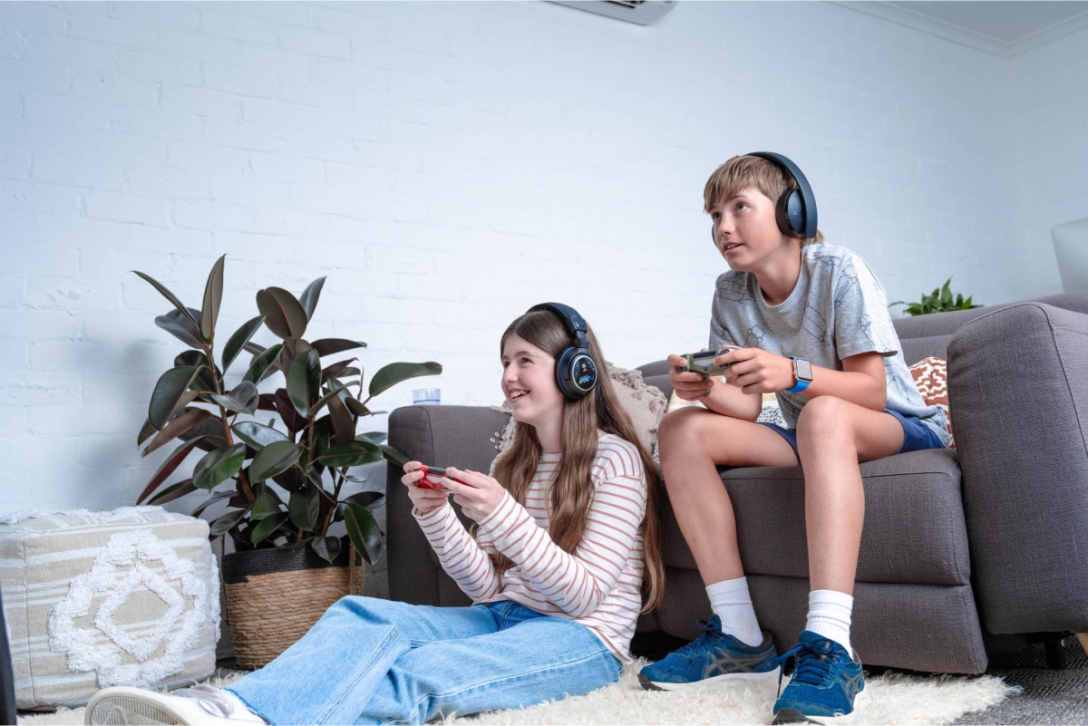 Two kids are playing games in the living room