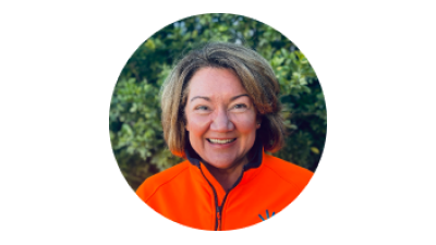 Profile photo of Jane Callinan, smiling outdoors in an orange jacket.