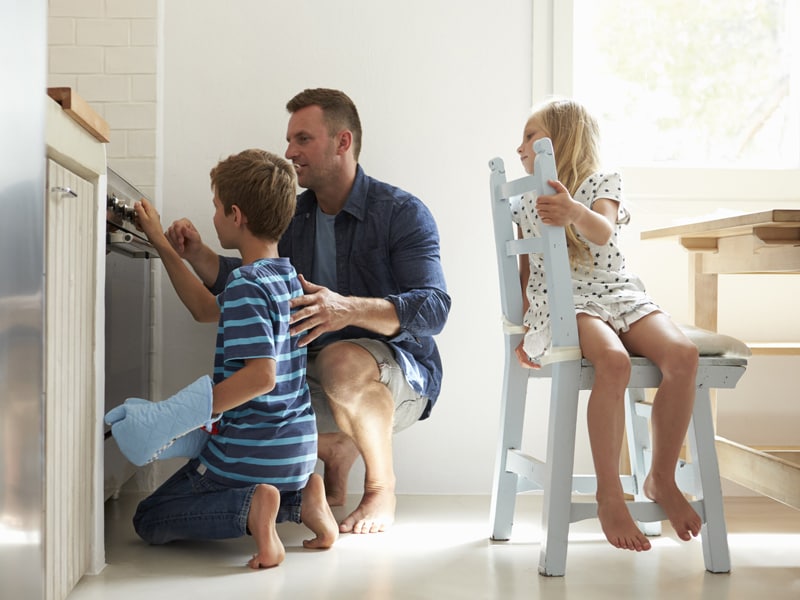 Father and two children cooking in the kitchen