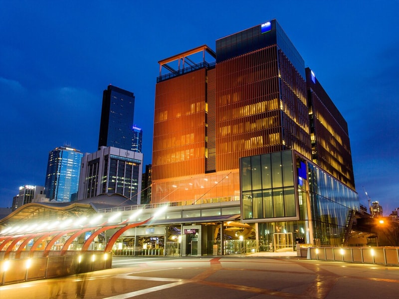A night time photo of an office building with the AGL logo on the top floor.