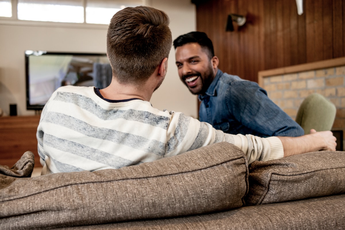 Two men sitting on the couch chatting