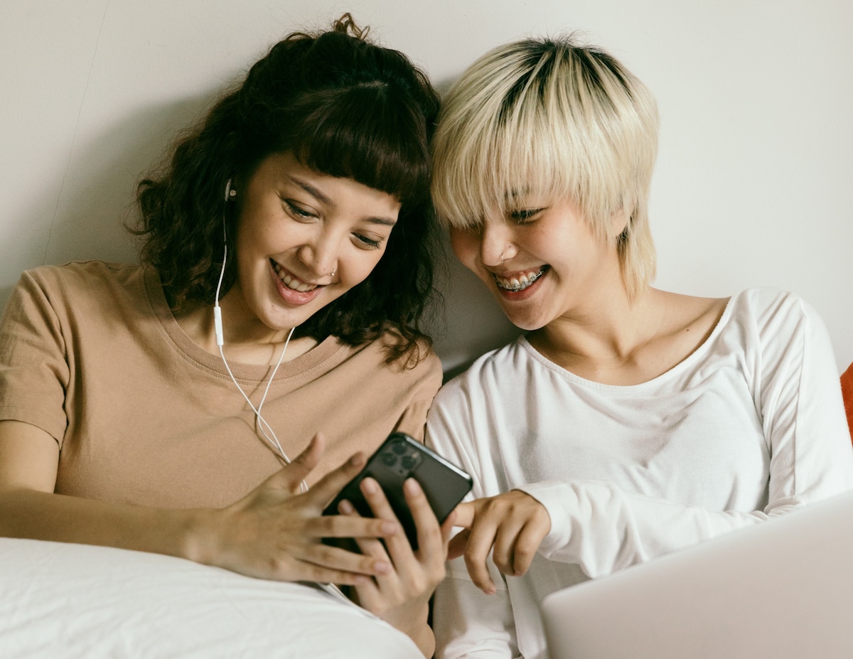 Young girls laughing looking at mobile