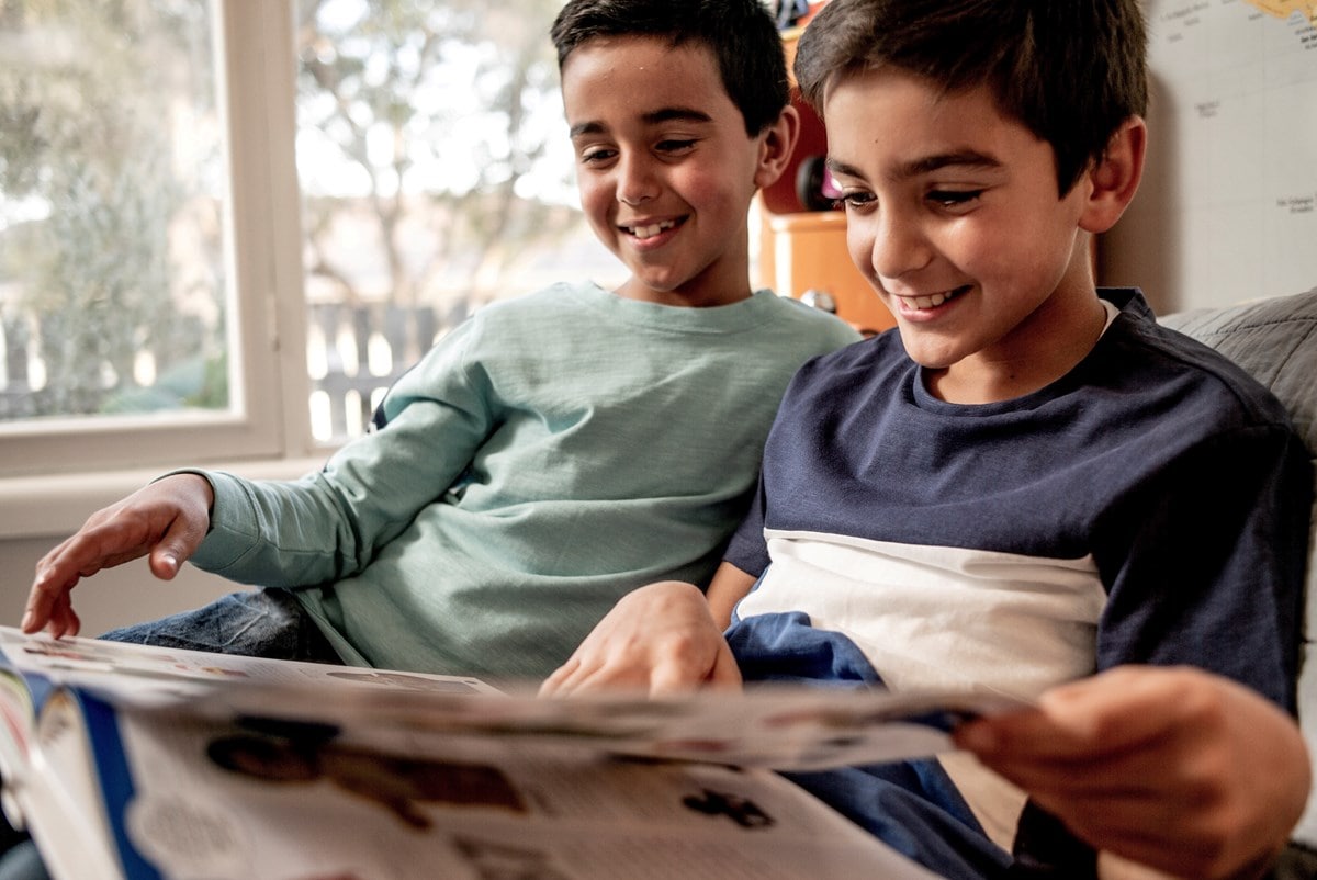 Two brothers reading in their bedroom