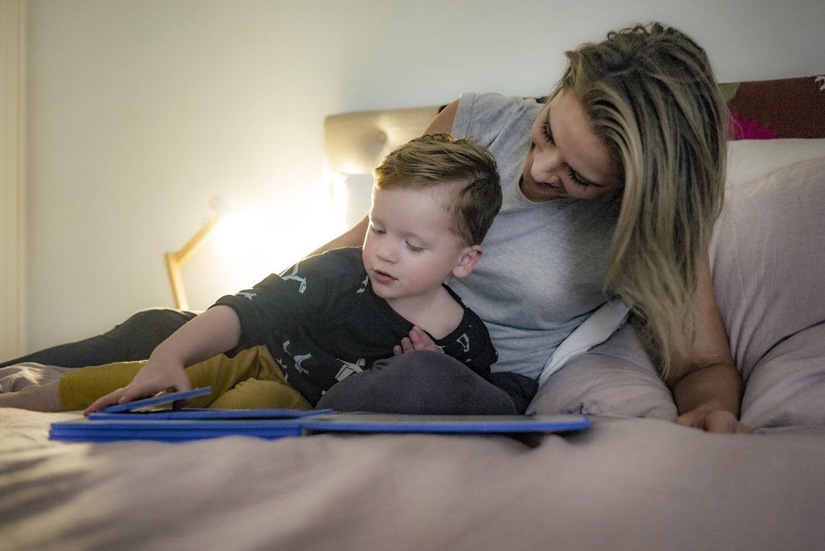 Mother and son reading books at bedtime