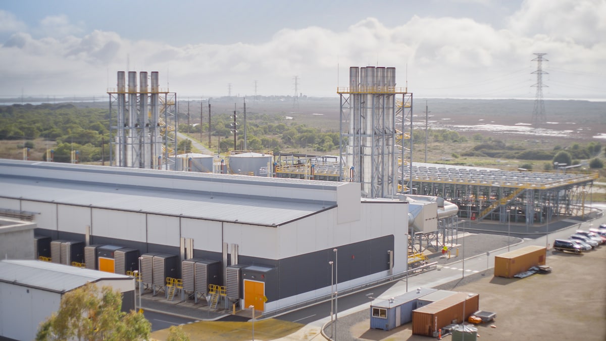 An aerial view of the Bayswater Power Station on a sunny day with cooling towers emitting steam.