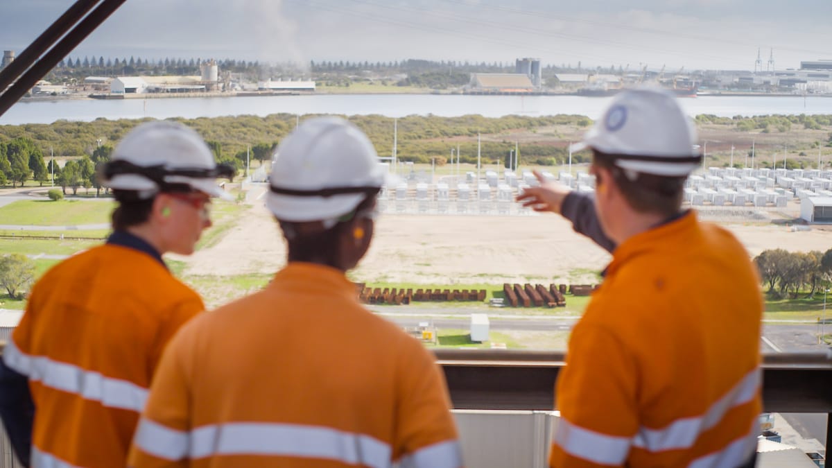 Three people in high vis at Torrens Island Power Station looking off into the distance
