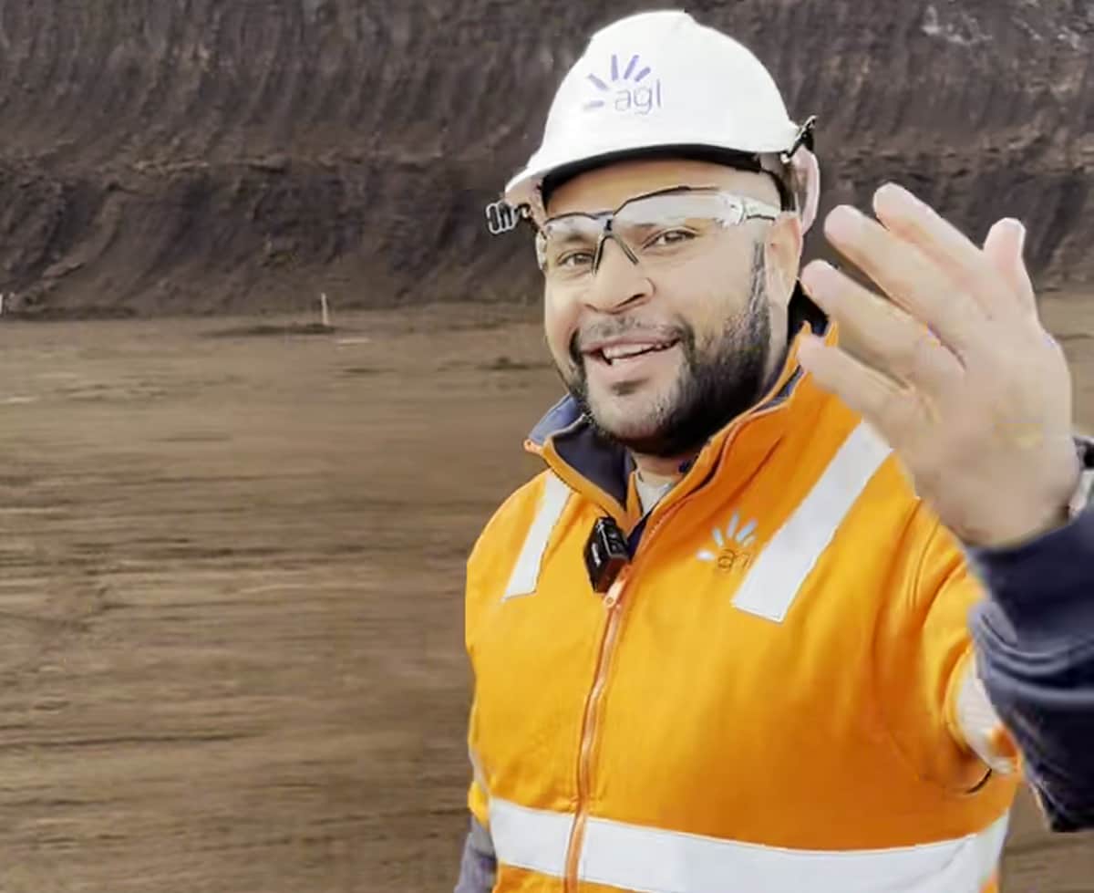 Mathias in a high vis jacket and a helmet, smiling. 