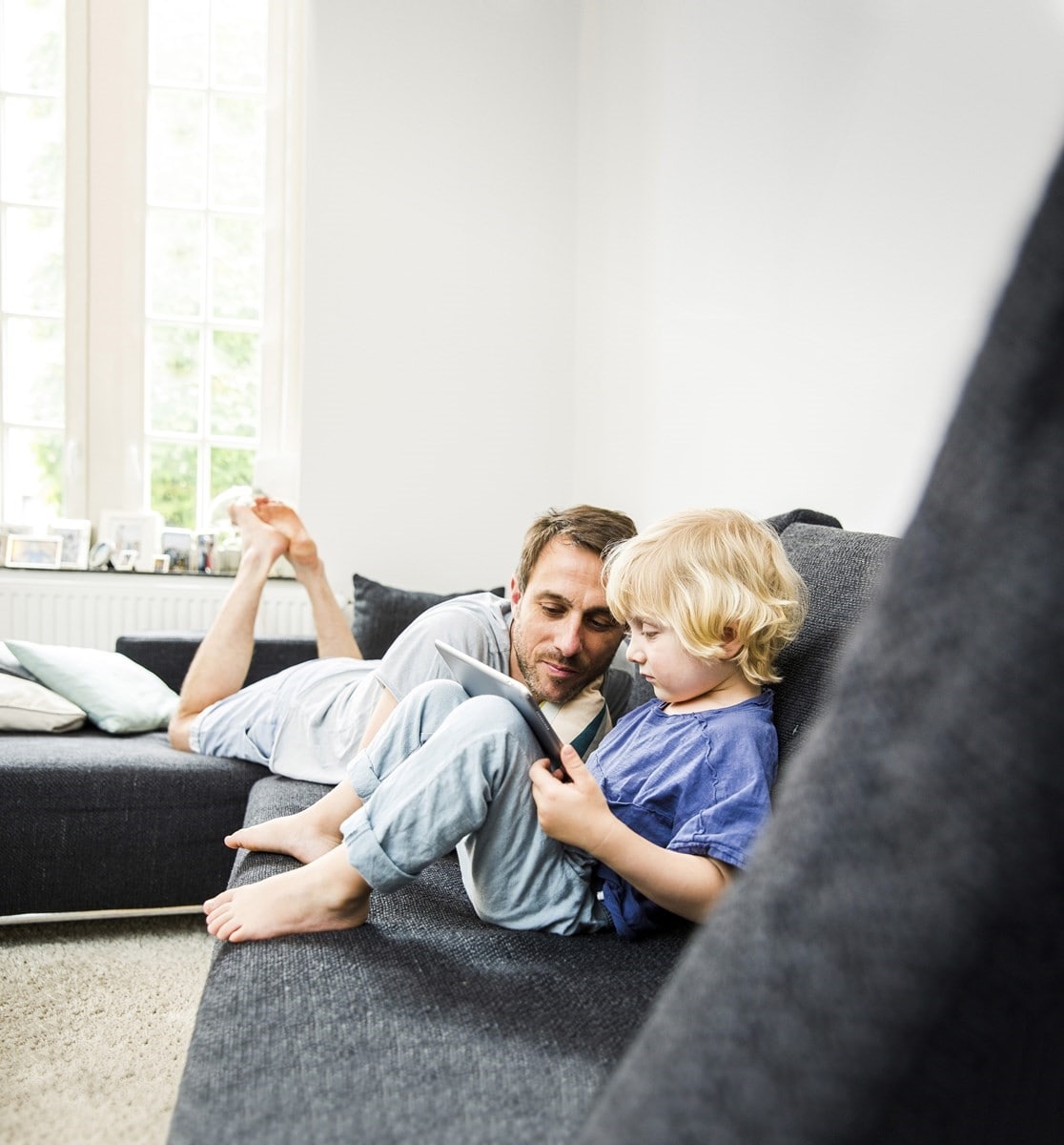 Father and son watching something on their ipad in their loungeroom