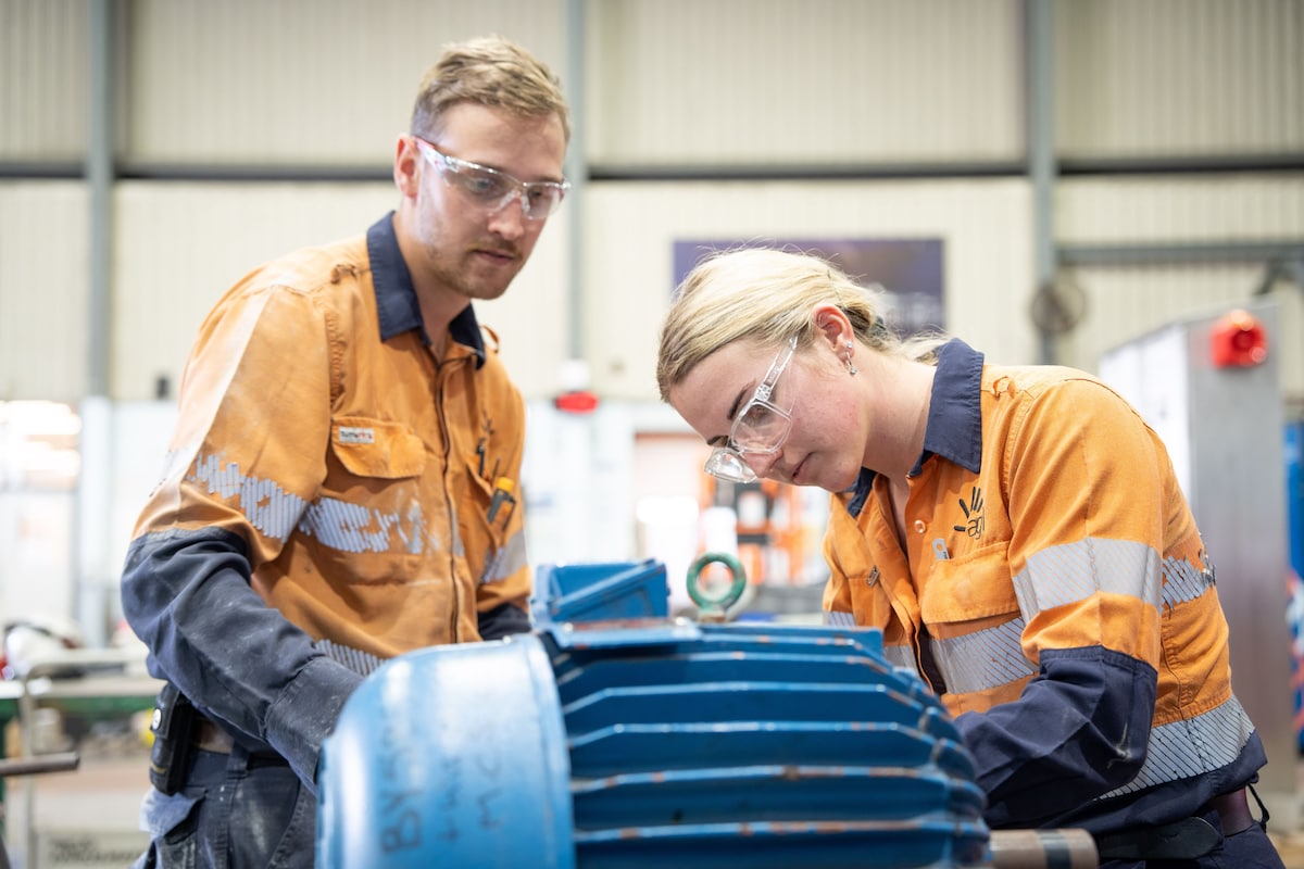 Two AGL team members working on a machine