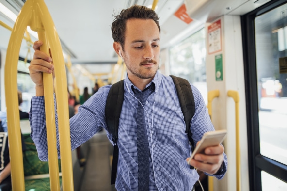 A man texting on his phone while on public transport