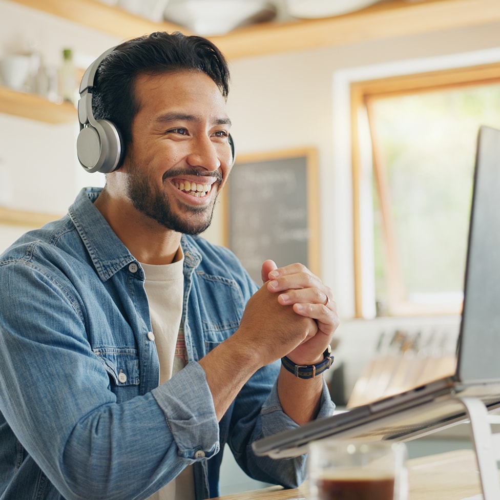 Person working on laptop wearing a headset