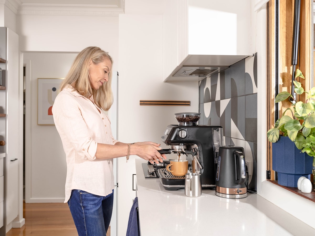 A woman making coffee in a kitchen