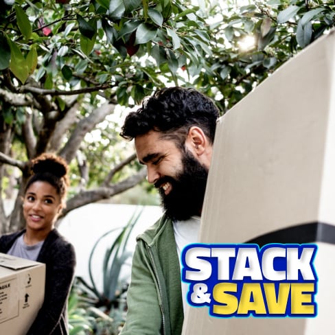 A man and woman moving boxes from their car.
