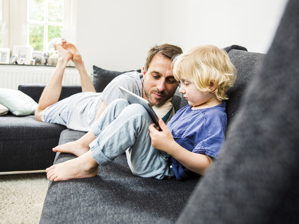 Dad and son on the couch using a tablet device