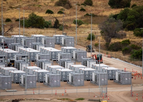 Industrial area with generators behind a chain fence