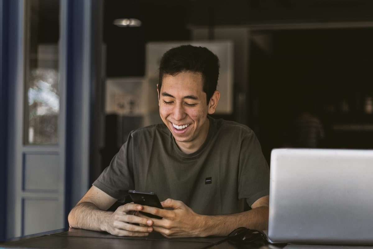 Man smiling at mobile phone