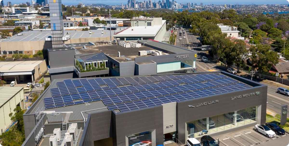 Aerial shot of the front and top of a car retail building with solar panels on the roof
