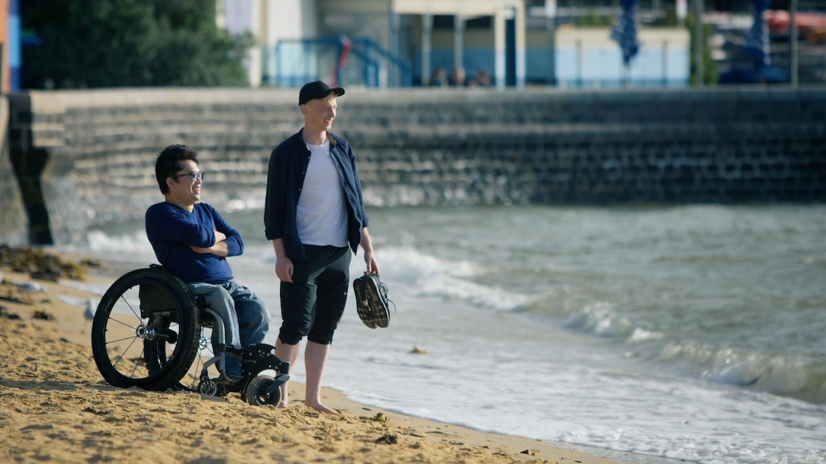 Man in wheelchair at the beach with a friend