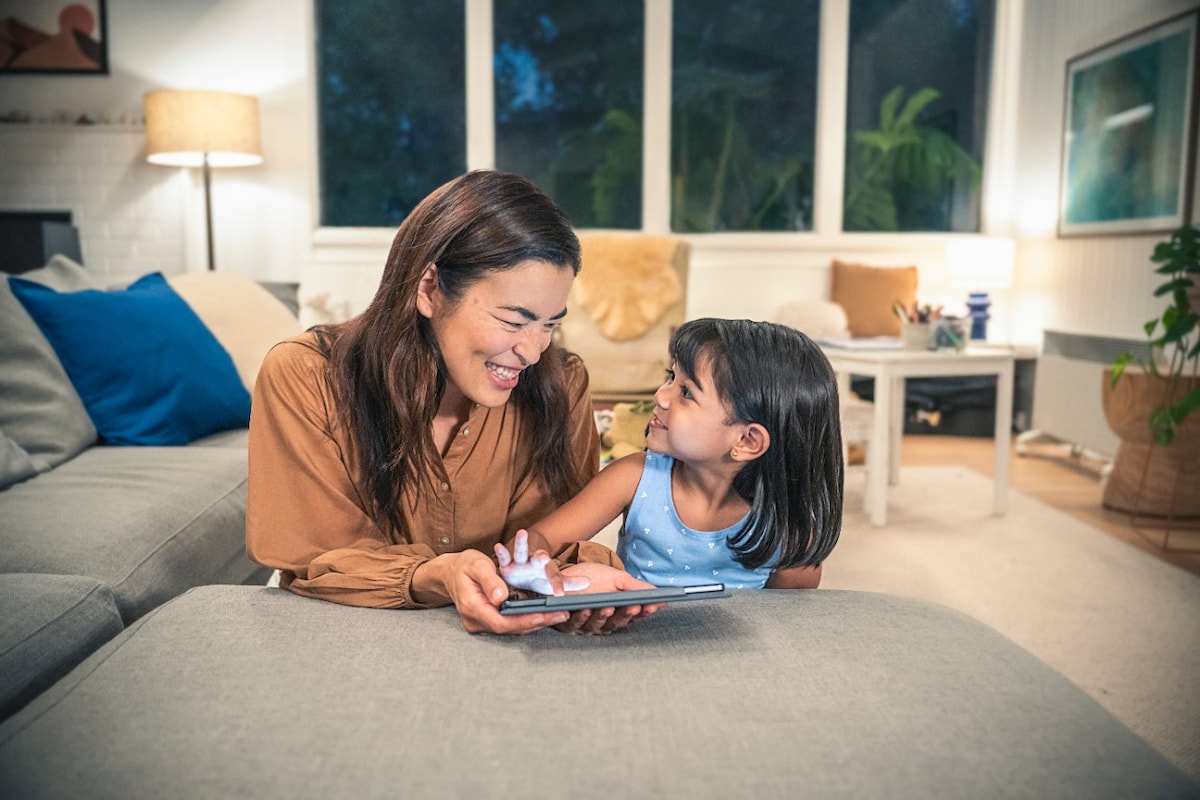 Mum and daughter in lounge room on tablet