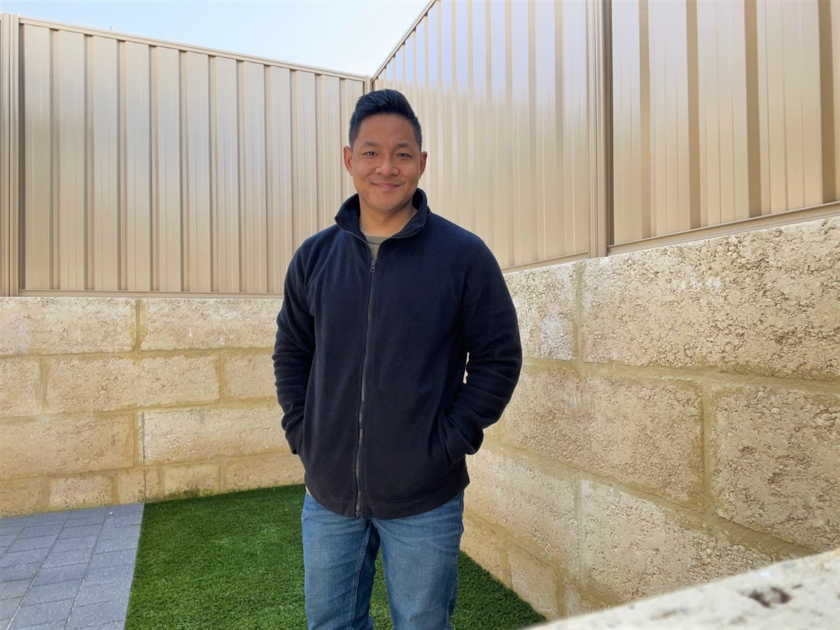 Joshua standing in his backyard