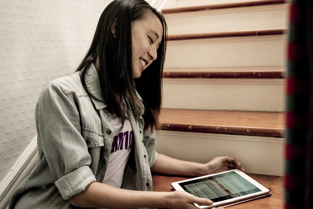 Young woman using tablet on stairs