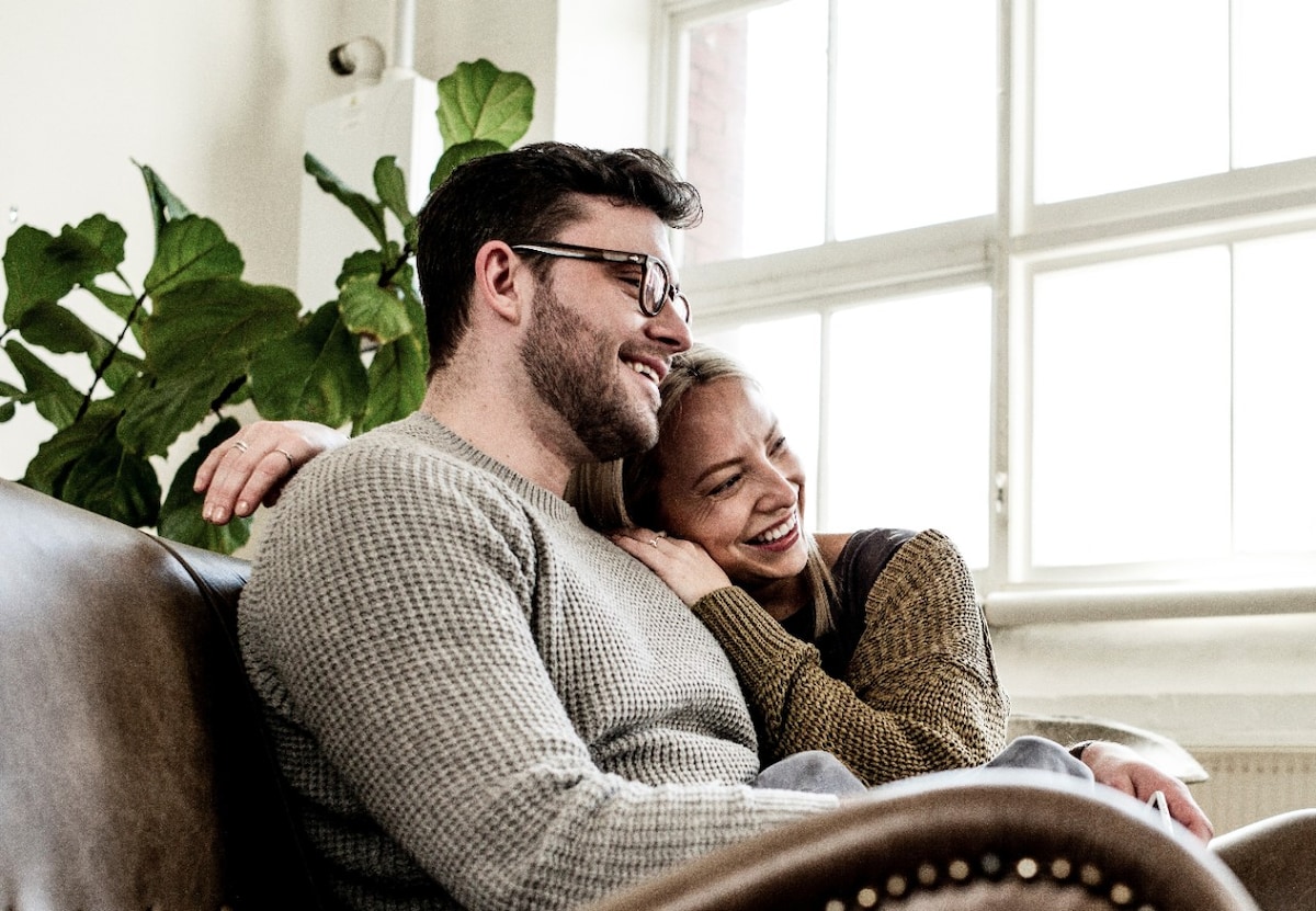 Happy couple cuddling in an armchair