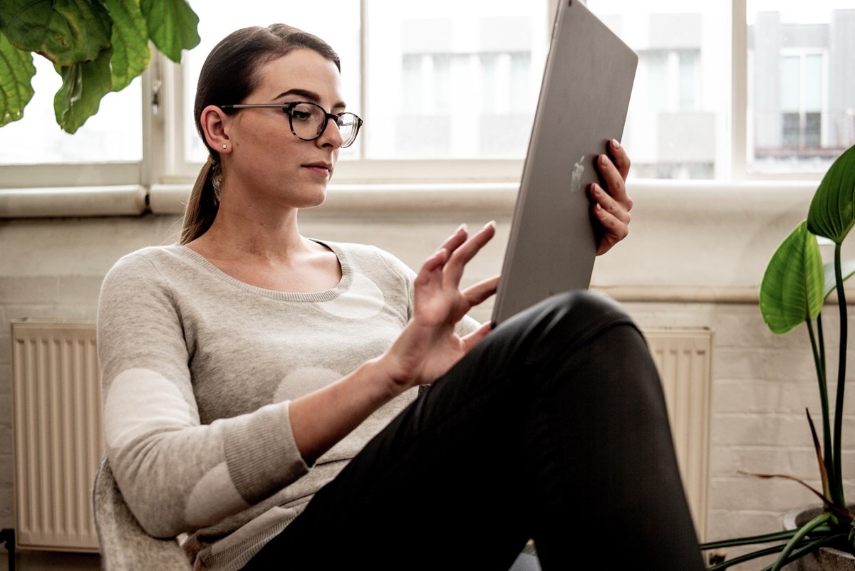 Young woman sitting in armchair with tablet