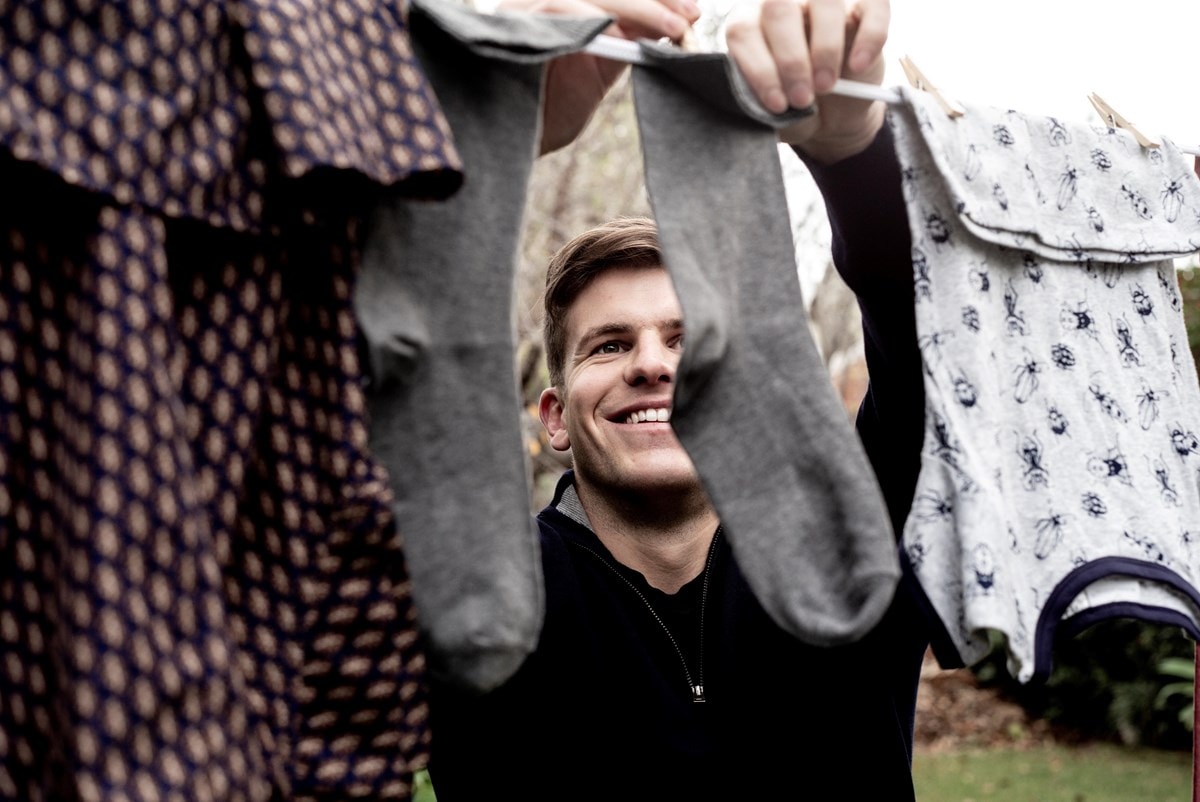 Man hanging clothes on clothesline
