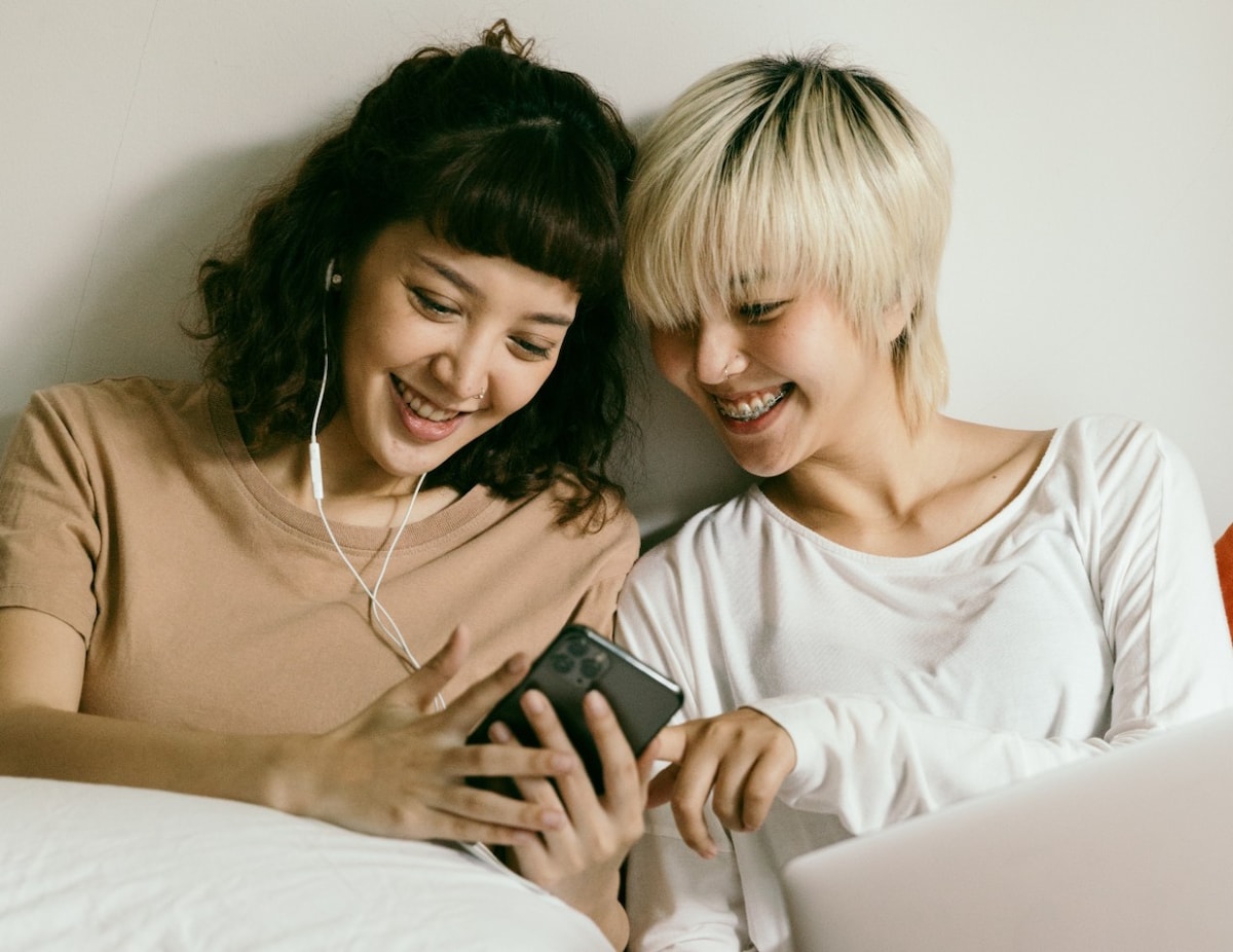 Young girls laughing looking at mobile