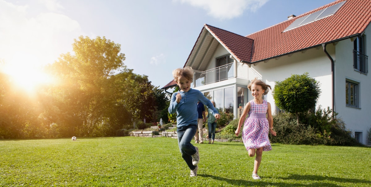Kids running from house into backyard at sunset