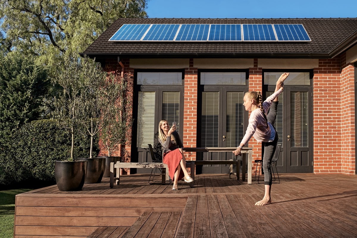 Mother and daughter on back decking with residential rooftop solar