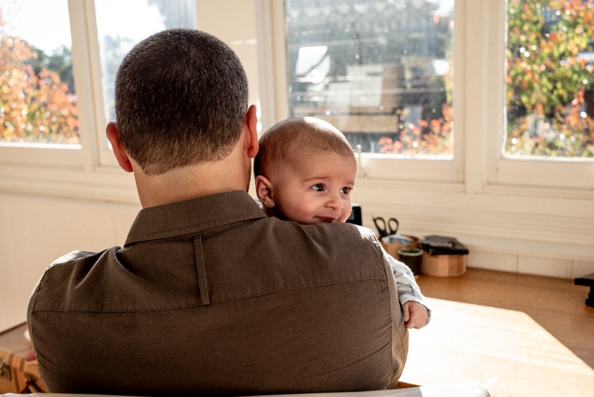 Man holding baby in living room