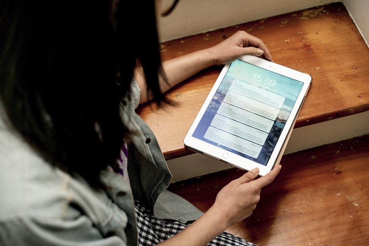 Woman sitting on stairs with tablet