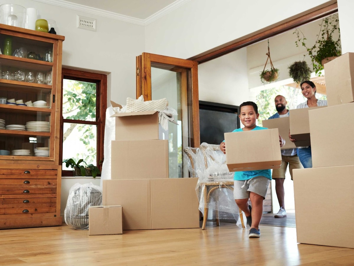 Man, woman and child holding moving boxes
