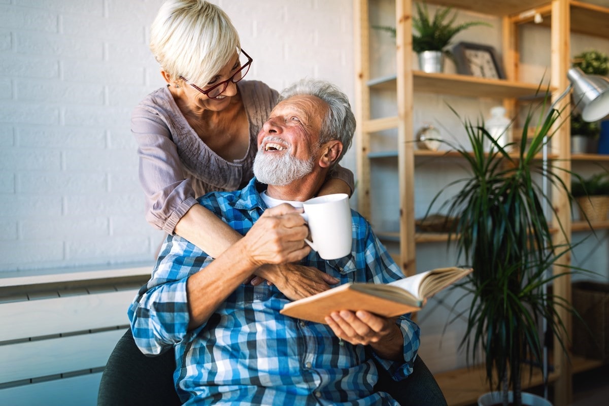 Happy senior couple in love hugging and bonding with true emotions at home; Shutterstock ID 1557209120; purchase_order: 91739; job: AGLC0225; client: AGL; other: Karin Ericsson