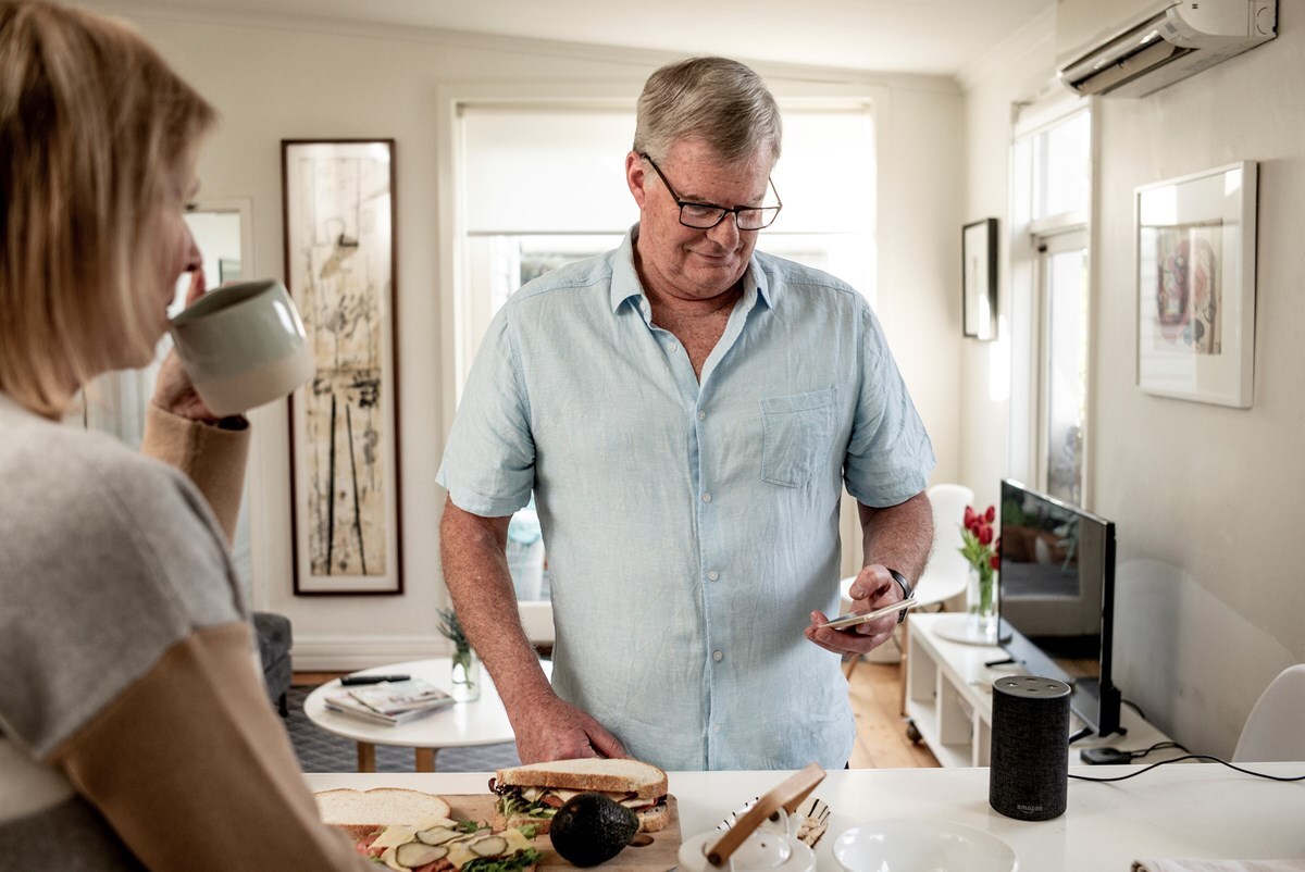 A man and a woman eating lunch in the kitchen