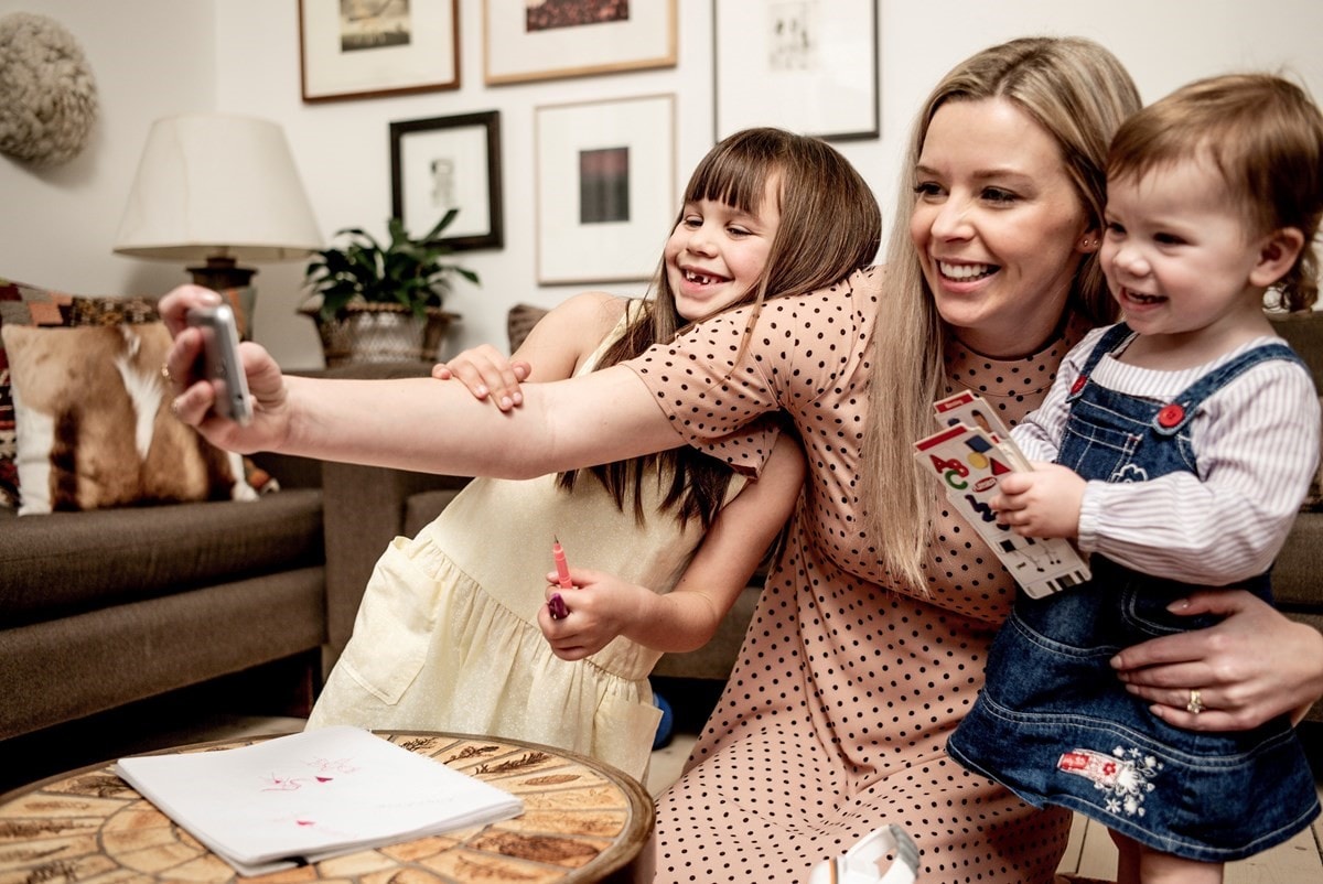 Mother taking selfies with her daughters