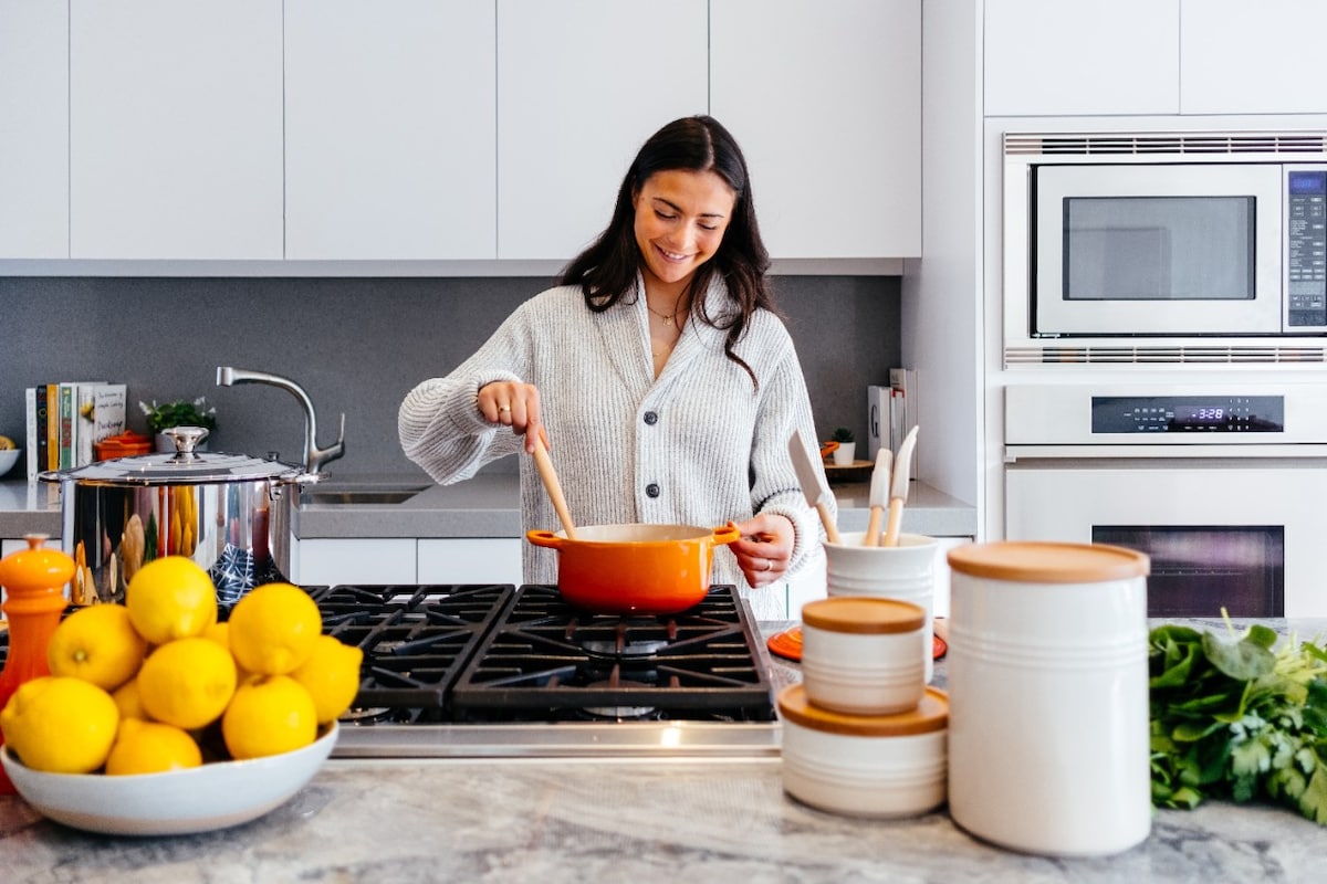 Young woman on gas stove in kitchen