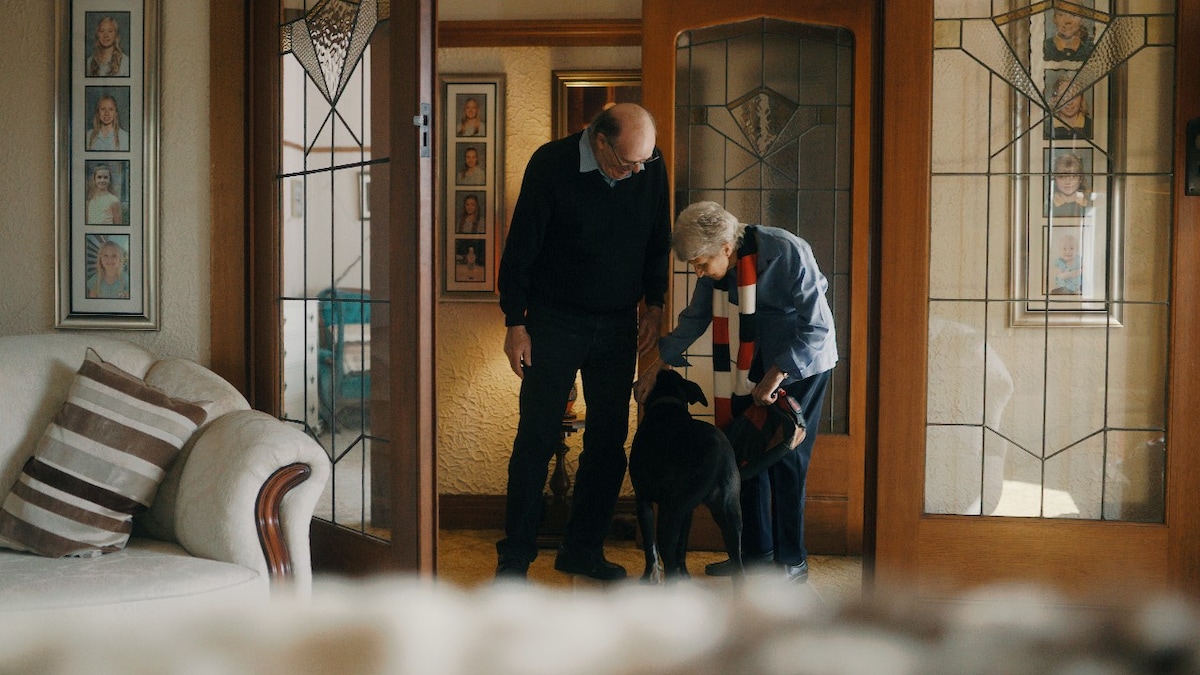 Husband and wife in the hallway with their dog