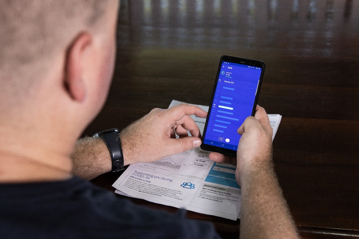 A man looking at the AGL app