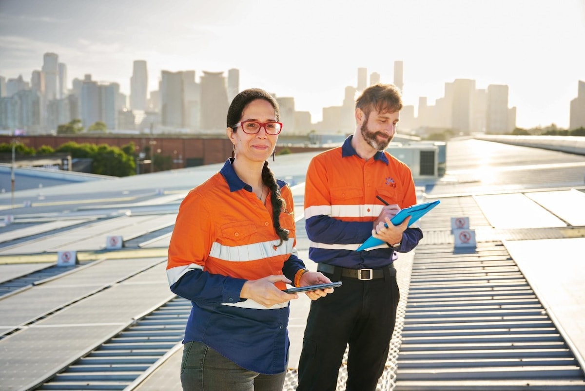 Two solar panel workers on the roof inspecting the application