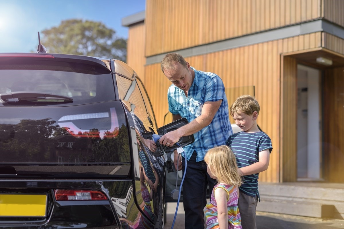 Family outside home charging EV
