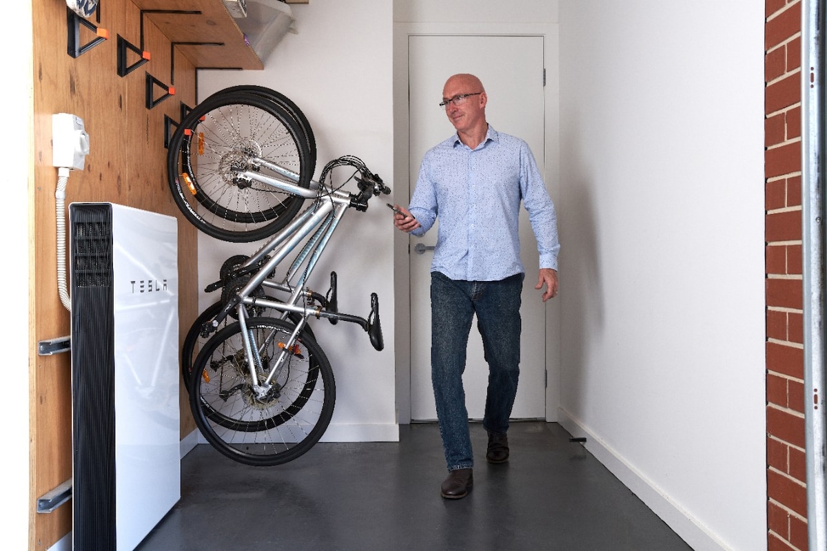 Darren with his Tesla Powerwall battery installed in his garage