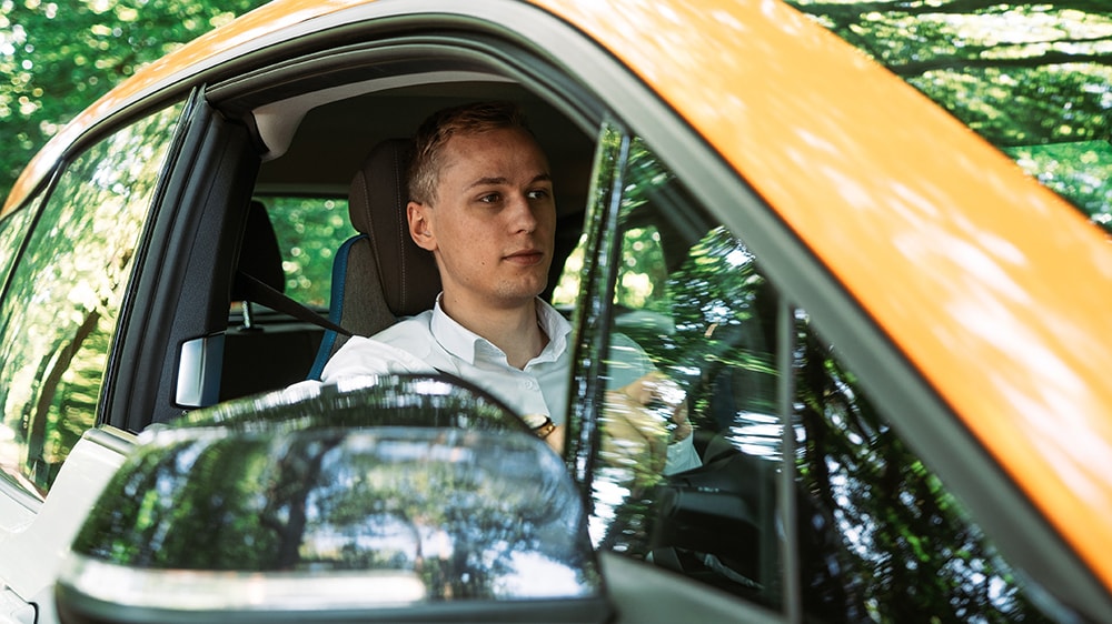 Man sitting in driver's seat of an eclectic car