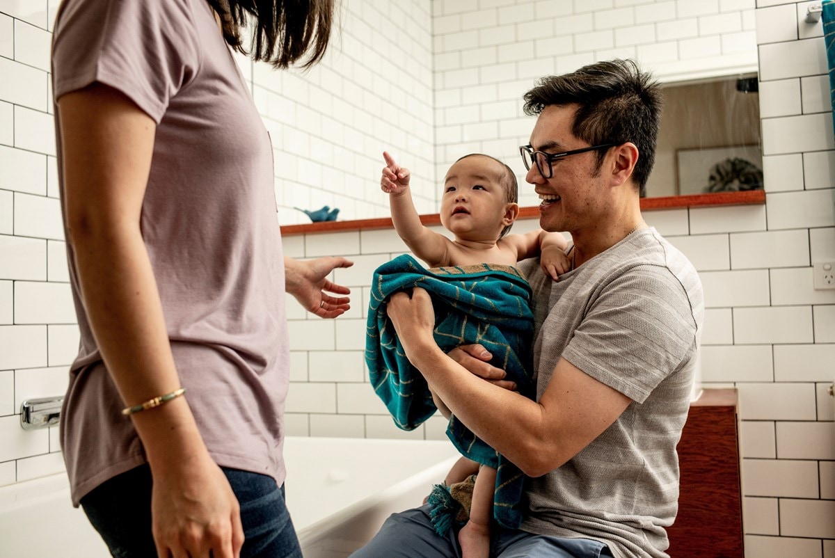 Husband and wife bathing their baby