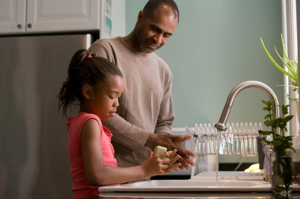 Father and daughter washing dishes together