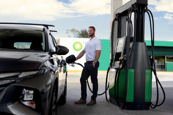 Man putting petrol in his car at a bp service site.